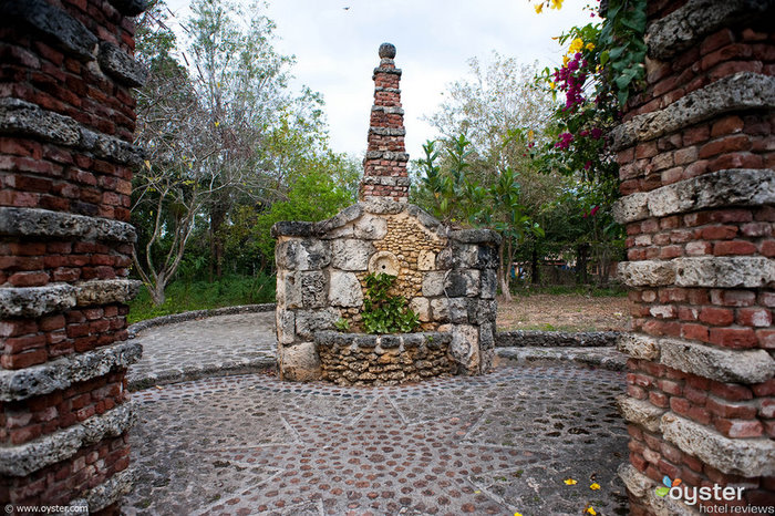 Small stone structures and overhanging flowers create an Old World feeling.This stone courtyard is located outside of a small church within Altos de Chavon.