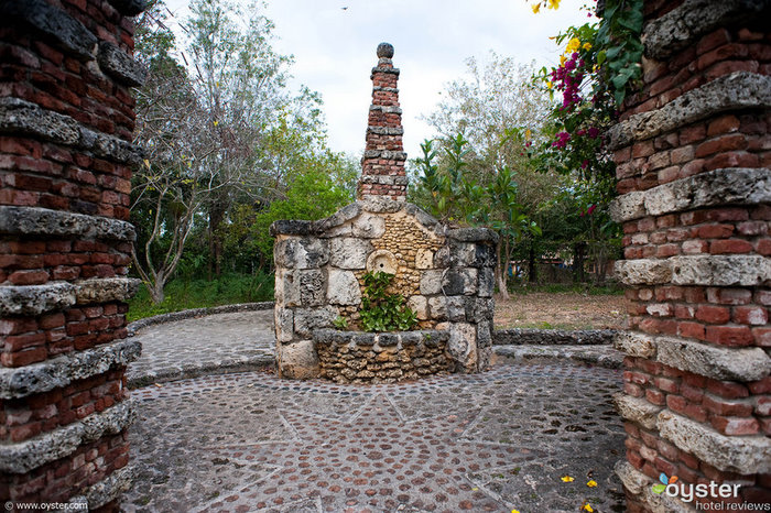 Kleine Steinstrukturen und überhängende Blumen schaffen ein Gefühl der Alten Welt. Dieser steinerne Innenhof befindet sich außerhalb einer kleinen Kirche in Altos de Chavon.