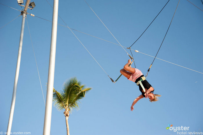 Un turista disfruta de clases gratuitas de trapecio en el Viva Wyndham Dominicus Palace Resort.