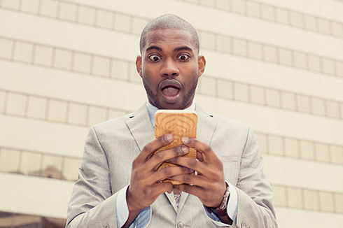 (Photo: Homme lisant des nouvelles sur téléphone portable via Shutterstock)