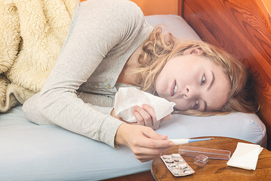 Foto: Mujer enferma en la cama a través de Shutterstock