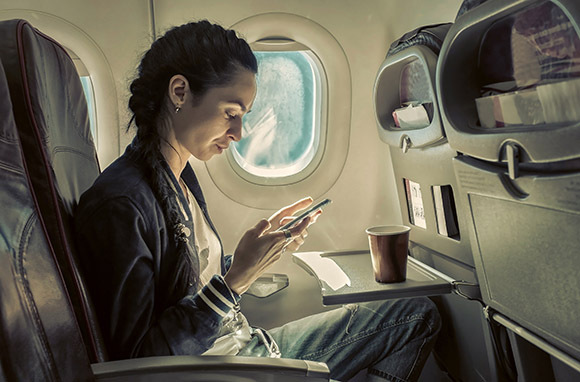 Photo: Woman Sitting on Plane via Shutterstock