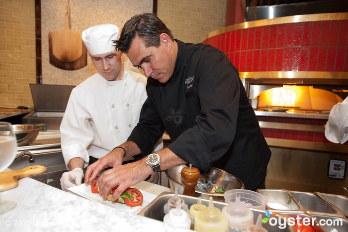Todd English preparing a plate on the Food Hall's opening day