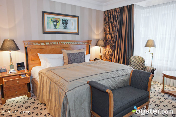 Elegant rooms have mahogany furniture, rich curtains, and plush bedding.