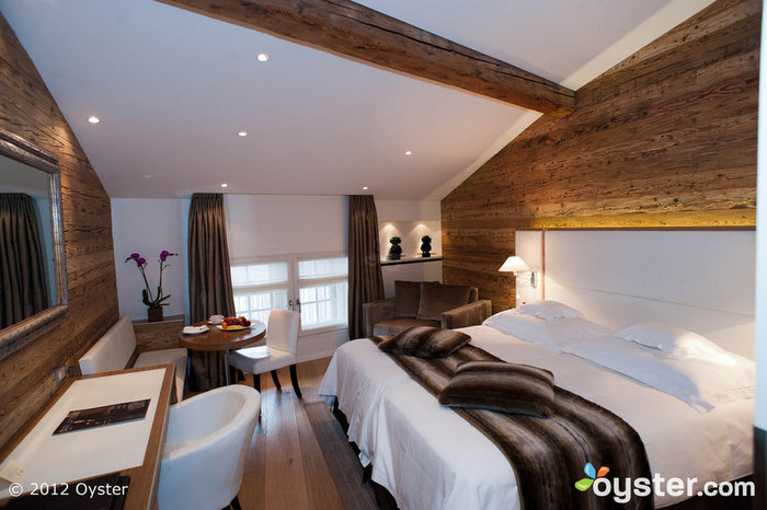 Les chambres sont équipées de jets de fausse fourrure et d'un combo sexy de meubles blancs et d'accents en bois.