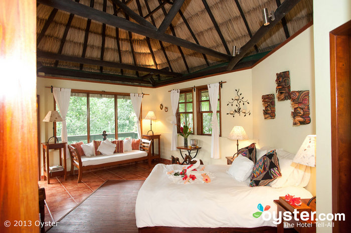 Rooms are housed in rustic-luxe thatched-roof cottages with wood and wicker furniture.