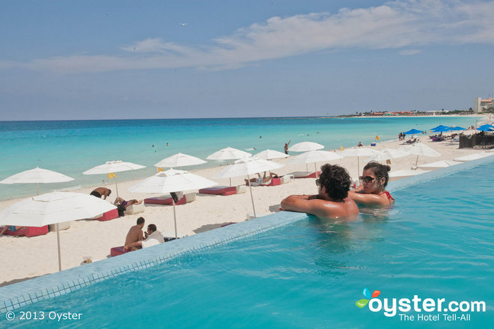 The gorgeous infinity pool overlooks a beautiful white-sand beach.