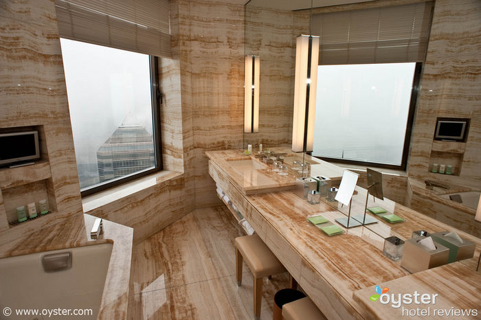 The marble bathroom looks out over the city.