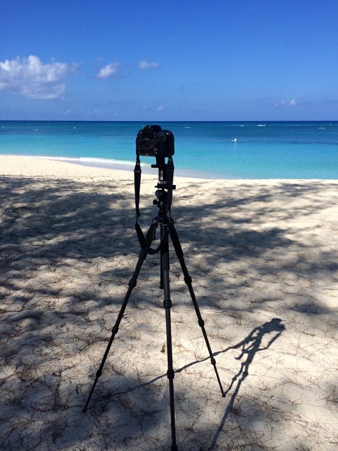 Maria configura sua câmera para fotografar um panorama da praia.