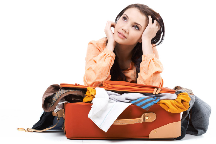 Femme avec des coudes sur la valise débordante via Shutterstock