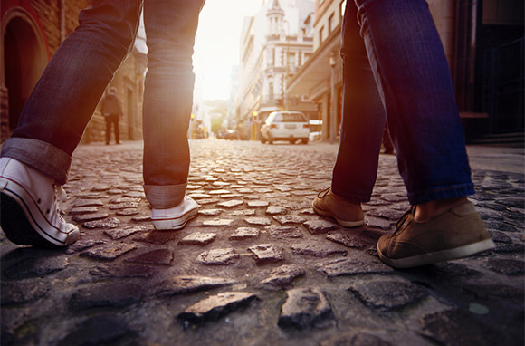Casal andando na rua de paralelepípedos via Shutterstock