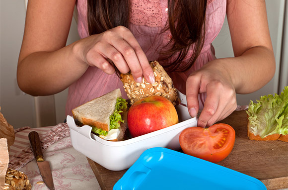 Mujer empacando un almuerzo a través de Shutterstock