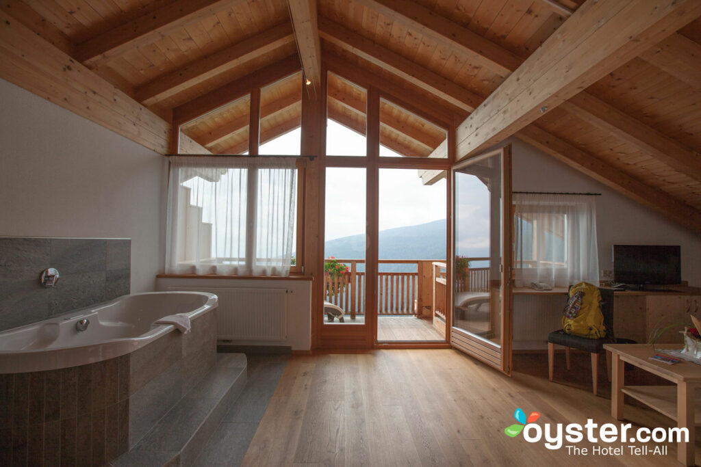Specialty suites include the Wellness Suite (shown here), with a deep soaking tub and wood-beamed ceilings.
