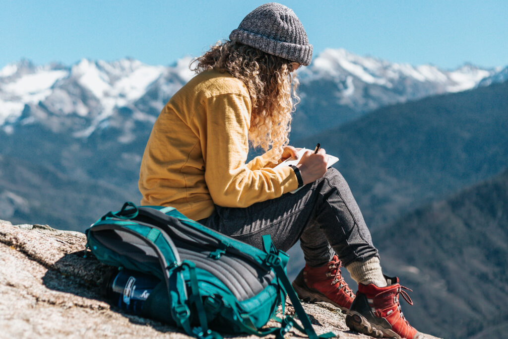 Woman journaling on a mountain