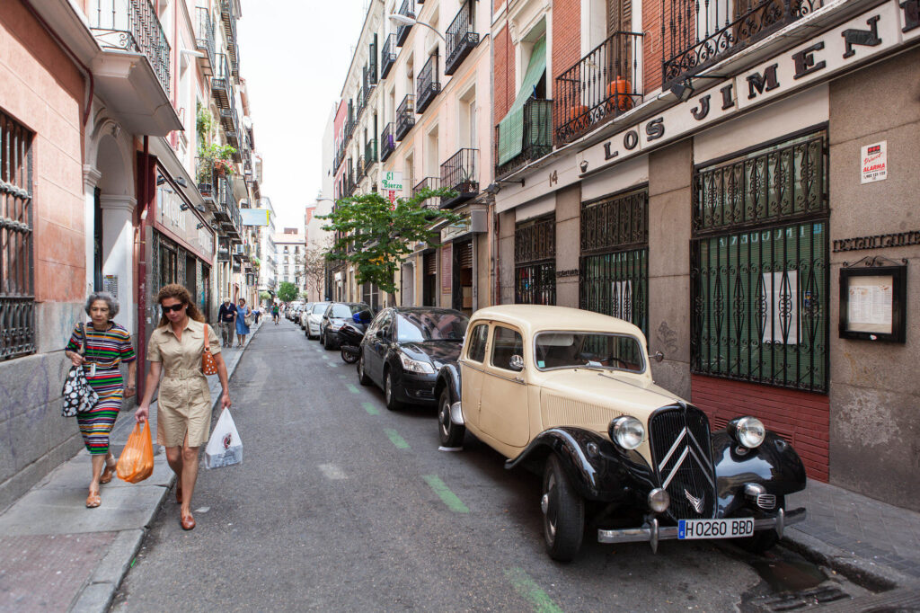 Chueca street with antique car and women shopping.