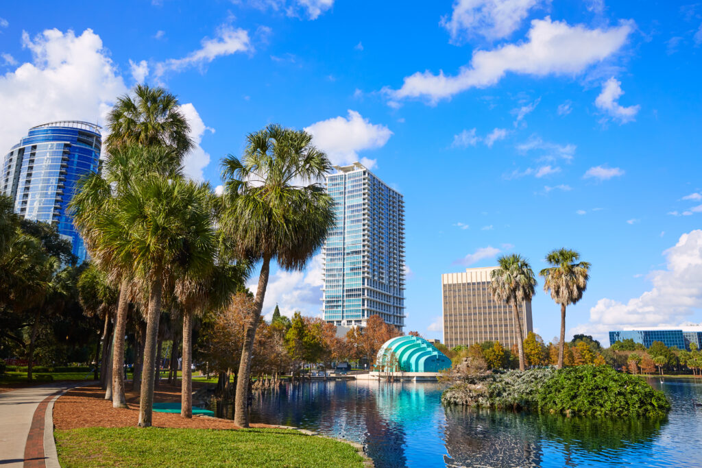 Skyscrapers and palm trees next to a lake in Orland, Florida on a clear day