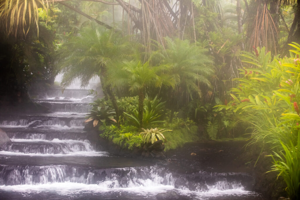 Water from thermal hot springs in the Arenal area of Costa Rica free flowing down stone steps
