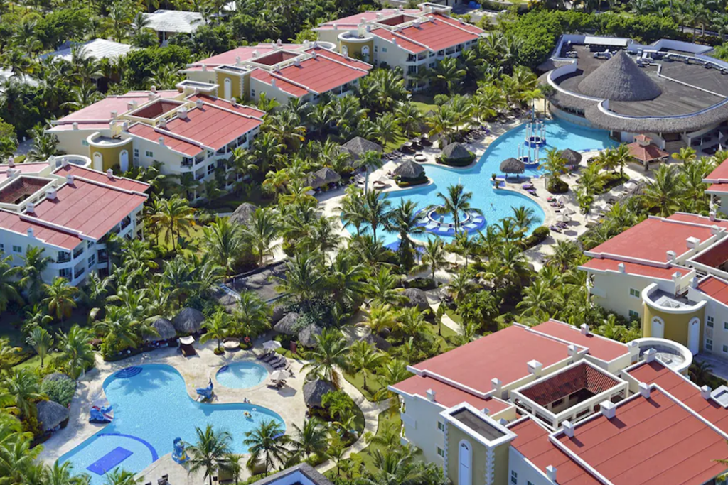 Aerial view of The Reserve at Paradisus Punta Cana Resort looking down at 2 pools and red roofed buildings