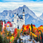Neuschwanstein medieval castle in Germany, Bavaria land. Beautiful autumn scenery of Neuschwanstein ancient castle circled by colorful tree, amazing seasonal fall scene. Famous and popular landmark.