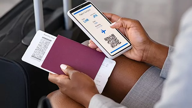 Close up of business woman checking flight e-ticket on phone at airport